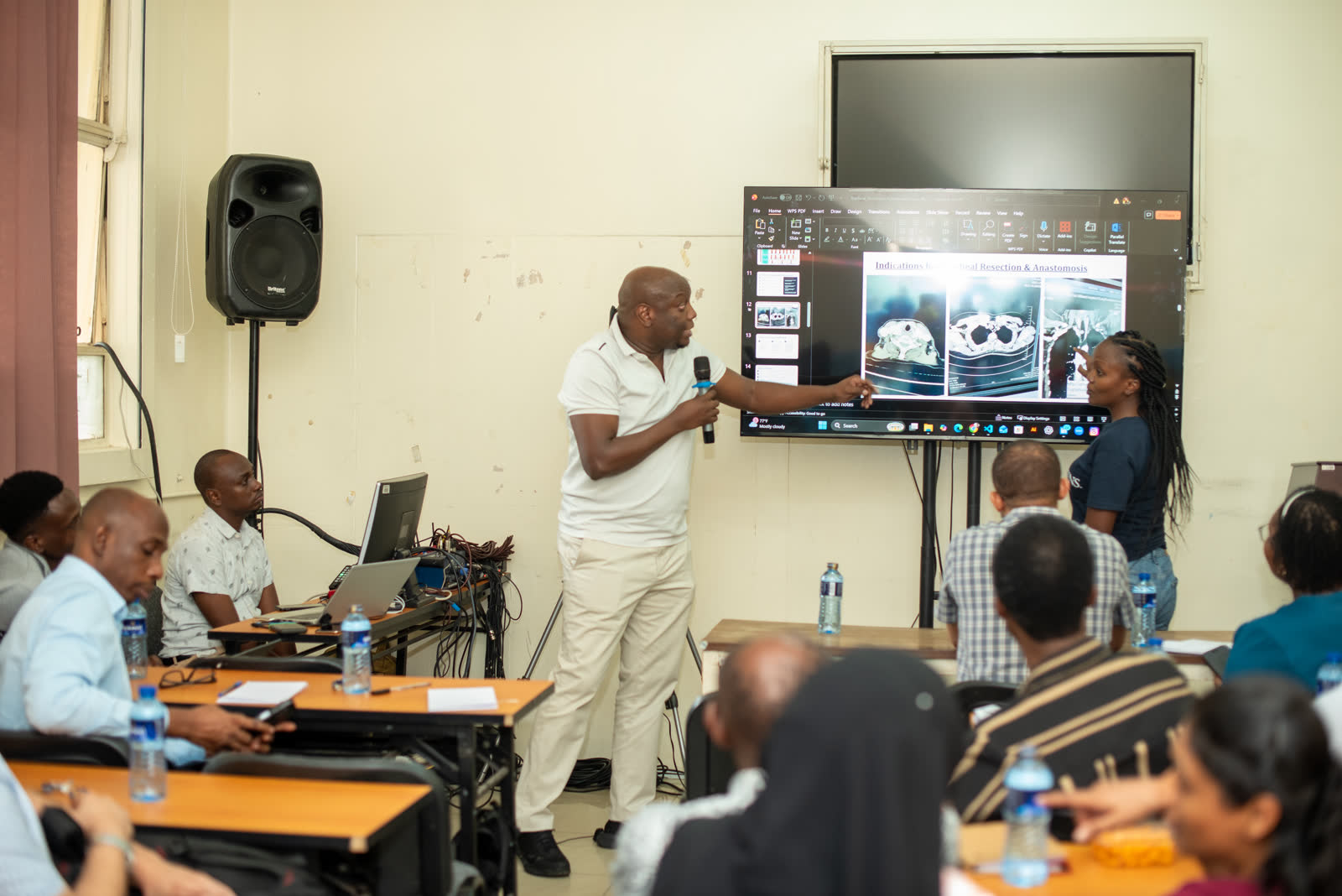 A facilitator talks participants through imaging on screen during a case discussion