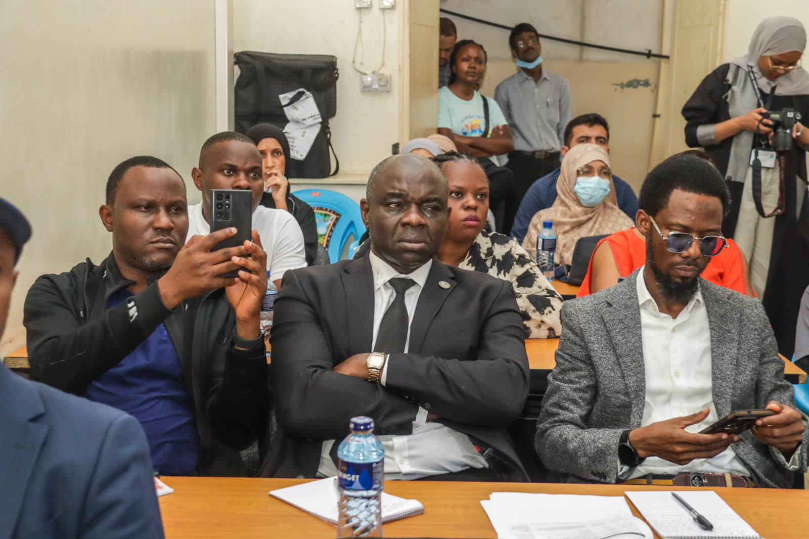 Delegates recording a presentation on their phones